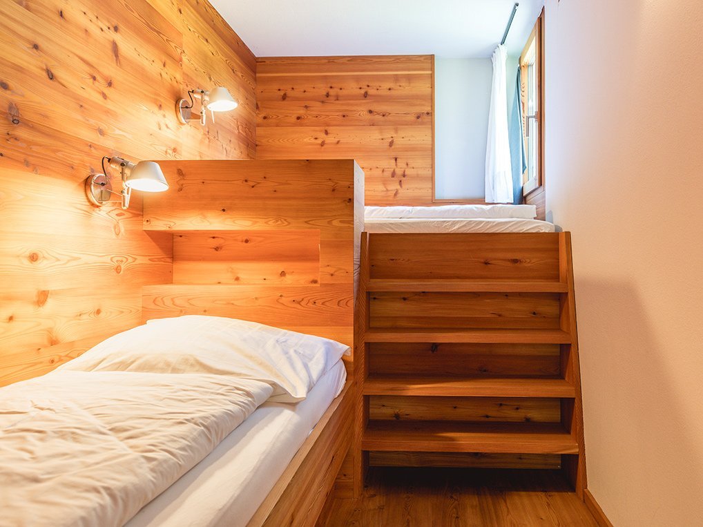 Ferienwohnung 4FLOSSE am Weissensee – Schlafzimmer mit Vertäfelung und zwei Einzelbetten